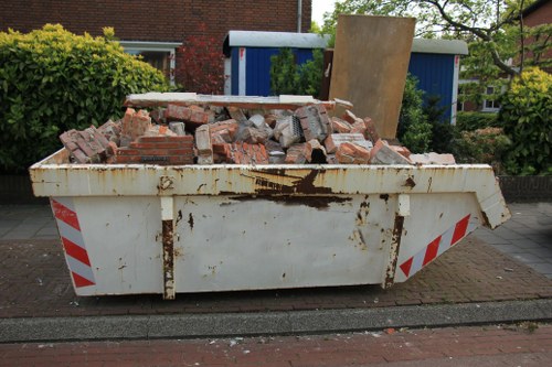 Residential street in Surbiton with a skip container placed on the sidewalk.